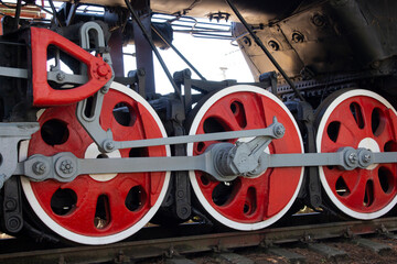 Locomotive wheels in red color close-up.