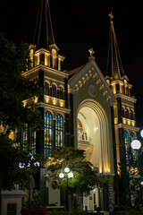 The Catholic Church Cathedral at night, illuminated by warm yellow light. Serene and picturesque view of the landmark. View of Ba Lang Church, Nha Trang city Vietnam. Travel photo. 