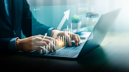 Businessman analyzing growth data using digital dashboard and laptop. Futuristic interface showing rising graph and financial metrics. Concept of smart investment, fintech, and business performance.