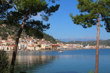 Greek village at the sea with pine trees, summer holiday postcard view (Gythio, Greece)