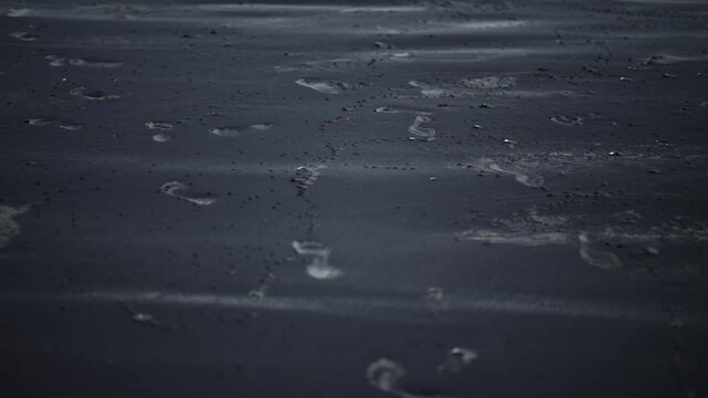 Low close up shot of black sand dunes forming in the wind
