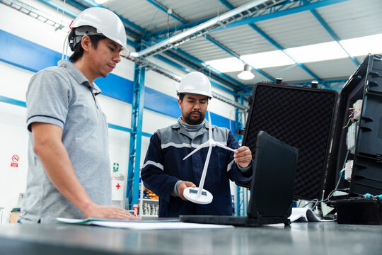 Engineers in a workshop inspecting renewable energy equipment