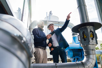 Engineers discussing plans at an industrial site outdoors