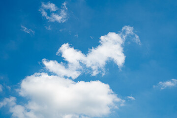 Fluffy white clouds against a bright blue sky.