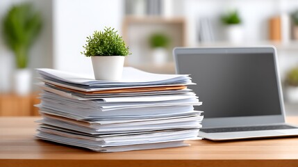 Overwhelmed by Huge Stack of Papers Next to Laptop on Desk in Office Setting
