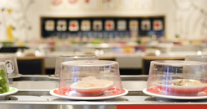 Sushi plates gliding along restaurant conveyor belt, transparent domes covering colorful rolls, showcasing culinary variety for hungry diners