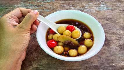 Traditional Asian handmade sweets, Chewy glutinous rice balls, Yuanxiao, Tangyuan, Sticky rice dumplings, sweet soup with brown sugar, red dates, dried longan, tasty Chinese food