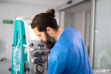 Doctor operating a medical device for blood transfusion in hospital room