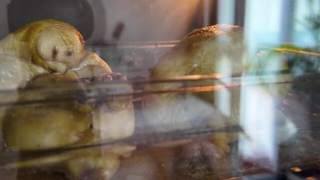 Poulets ou coquelets en cuisson dans un four maison avec reflets dans la vitre 