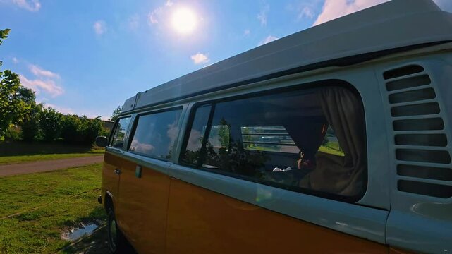 un Van jaune et blanc gar&eacute; en plan rapproch&eacute; de la carrosserie au halo lumineux
