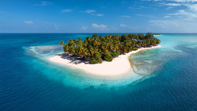 A drone view of an island with white sand in the middle of the ocean. Turquoise water, coral reef. There are palm trees all around. Maldives