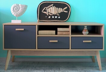 Chest of drawers with marine items and a picture of a fish. Marine style in the interior of the room