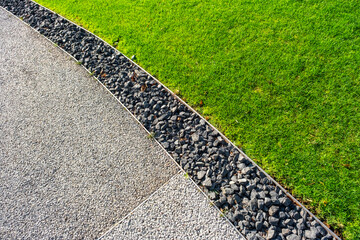 An attractive composition of green grass, small smooth pebbles and concrete, ideal for landscaping...