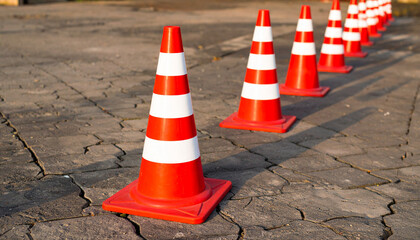 Red and White Traffic Cones Lined Up on Pavement