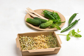 Sprouted grains of wheat, peas and mung bean in cardboard container.