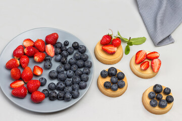Blueberries and strawberries on gray plate.