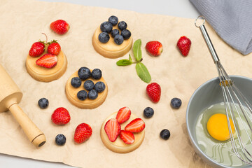Blueberries and blueberries on table. Tartlets with berries on brown paper.