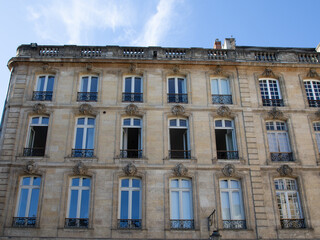 old and stylish hausmann building facade in french city bordeaux with open windows