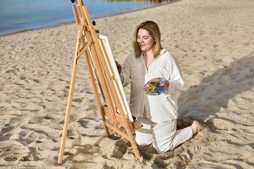 Young woman paints on beach, blending tranquility of ocean with artistic expression. Vibrant scene...