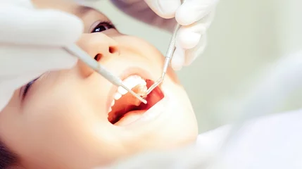 Acrylglasbilder Zahnärzte A young child sits comfortably in a dental chair, opening their mouth wide as a dental professional examines their teeth. The atmosphere is calm, focusing on a routine dental checkup and care  © Stockify Pro