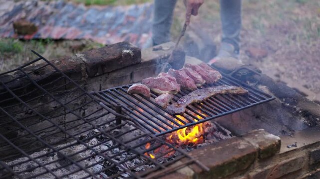 Outdoor grilling scene to making Skirt steak aka Entraña and Top Sirloin Cap aka Picaña over open fire.