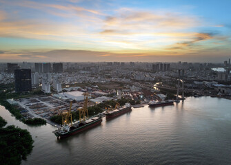 Phu My bridge spans the Saigon River at sunset over Ho Chi Minh City, showcasing urban development and industry