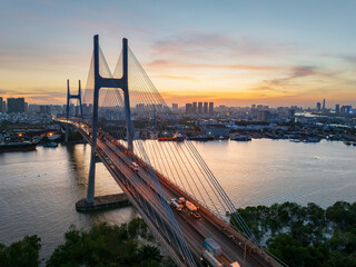 Stunning sunset casts warm glow over Phu My bridge in Ho Chi Minh City, Vietnam with traffic flowing across the iconic structure