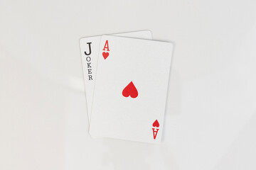 Ace of hearts and black joker card combination on white isolated background