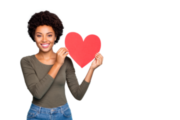 Portrait of positive dreamy dark skin girl hold big red paper card valentine heart for 14-february holidays enjoy date with sweetheart wear green sweater denim jeans isolated blue color background