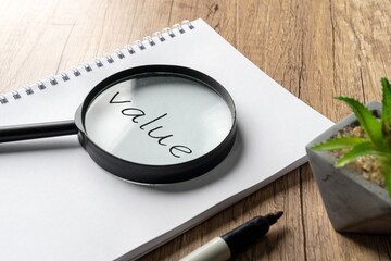 A magnifying glass placed over a notebook, enlarging the word 