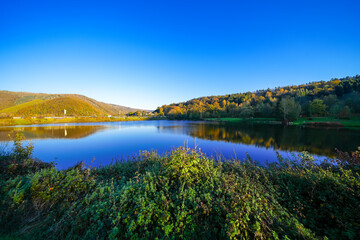 View of the Eiserbachsee lake in Rurberg near Simmerath. Landscape at the Eiserbach dam. Nature in the Eifel region.
