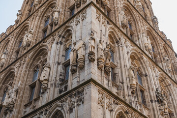 Tower of Cologne City Hall with many exterior stone figures seen on every side