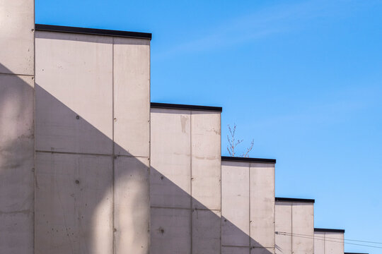 Fototapeta Concrete structure with geometric shadows, abstract building patterns, minimalist urban architecture, modern design, visual rhythm in sunlight.