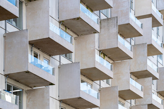 Geometric balconies in contemporary architecture, repetitive patterns, symmetry, urban facade, abstract design elements, light and shadow composition.