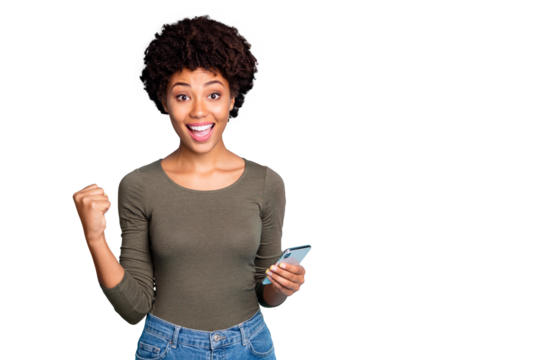 Yes more followers! Portrait of cheerful curly hair mulatto girl hold use smartphone get notification celebrate lottery victory raise fist scream wear green pullover isolated blue color background