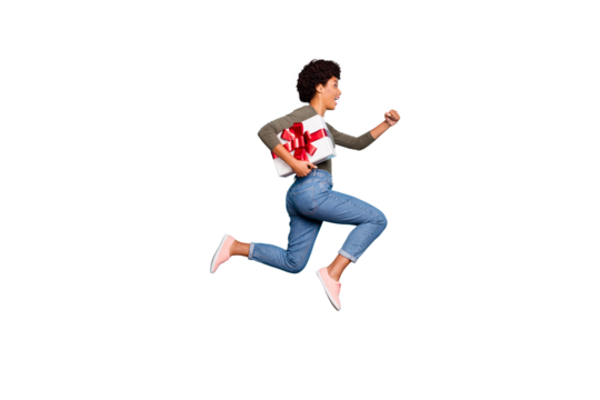 Full length profile side photo of funny cheerful brunette wavy hair girl hold big gift hurry to friends anniversary celebration party event jump run wear pullover jeans isolated blue color background