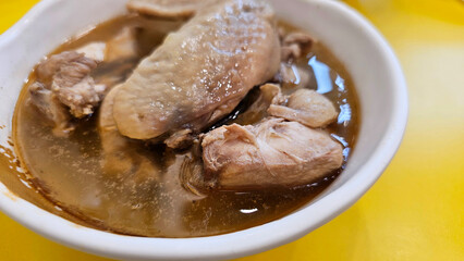 Enjoy eating traditional Chinese delicacies: sesame oil chicken and Soju wine cooked chicken soup — aromatic handmade broth simmered with bone-in chicken thigh pieces and served with dry wheat noodles