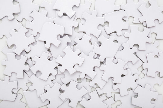 Different many white puzzle pieces background. Closeup. Top down view.