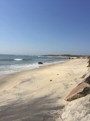 Serene beach with gentle waves and clear sky