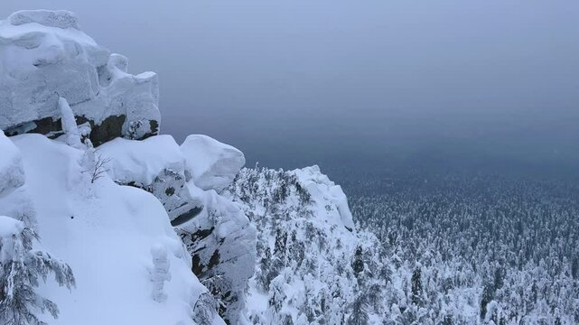 View of the white rocks and the winter forest on Mount Polyud. Lappish spruces on Mount Polyud in the Perm region in winter. In winter, there is a lot of snow and frost on the trees in the Urals. 4К
