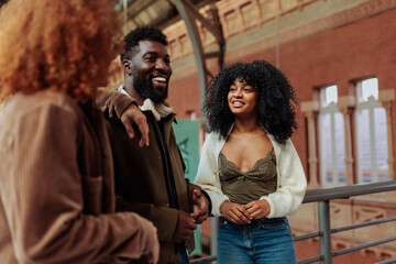 Group of young friends talking and smiling at train station