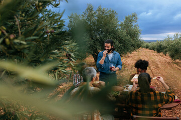Farmers enjoying a meal in olive grove after harvest