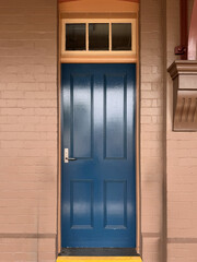old building renovation with restored wooden blue door with window above entrance 