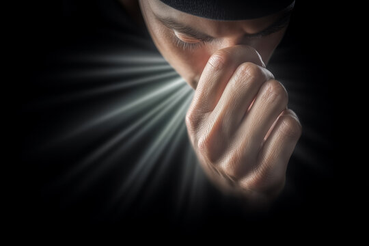 Dramatic Black and White Photo with Light on Clenched Fist and Face