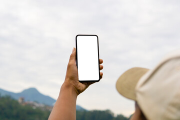 Man holding mobile phone with blank white desktop screen in the outdoor