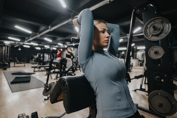A young individual performing a workout in a modern fitness center. The scene captures...