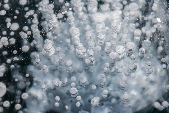 frozen air bubbles underwater over icy surface