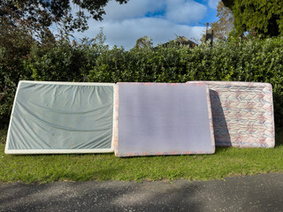 Three illegally dumped mattresses on the roadside. Blank copy space - add your own graffiti. In...