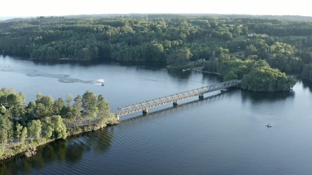 Aerial view of Pont de Lantourne bridge over lake, boats visible, surrounded by forest, Marcillac La Croisille, France