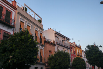 Fototapeta premium Historic Seville architecture with ornate facades, colourful exteriors, and traditional balconies reflecting Andalusian charm under the Spanish sun.